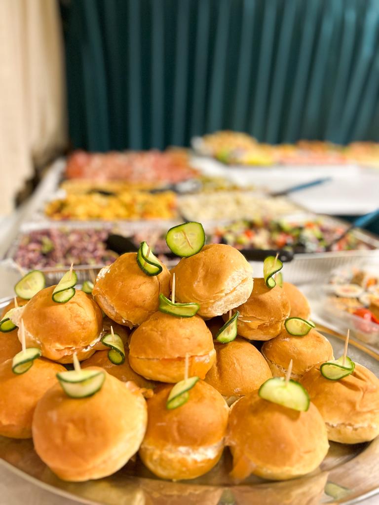 Buffet with a mountain of burgers in the foreground